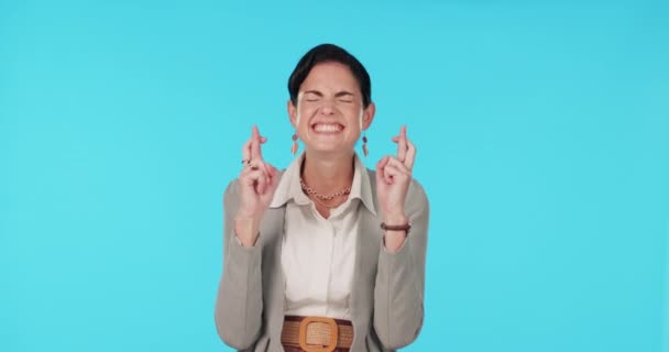 Face, woman and fingers crossed in studio, blue background and hope for success, business opportunity and good news. Portrait of excited female model, hands and wish for win, emoji and lucky fortune. - Imágenes, Vídeo