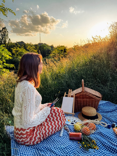 Paraíso de los pintores: la mujer crea arte durante el picnic. - Foto, Imagen