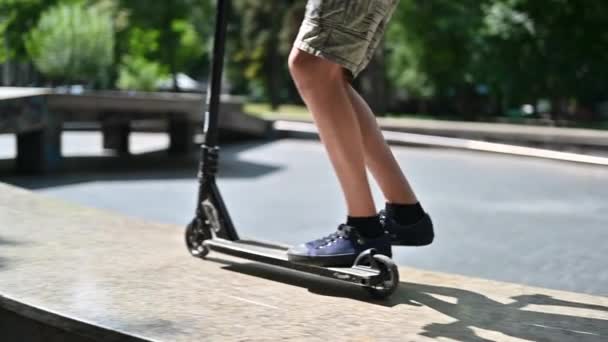 Niño saltando en un monopatín en un parque deportivo, cámara lenta - Imágenes, Vídeo
