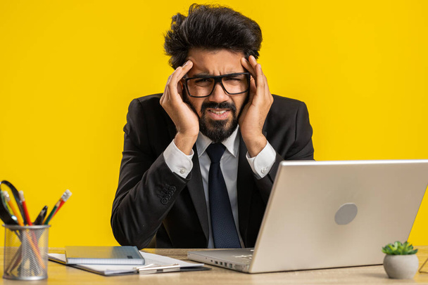 Müde krank indischen Geschäftsmann leiden unter Kopfschmerzen Problem Spannung und Migräne, Stress zu Hause Büro Schreibtisch Arbeitsplatz. Der bärtige, freiberufliche Makler arbeitet am Laptop. Überarbeitung - Foto, Bild