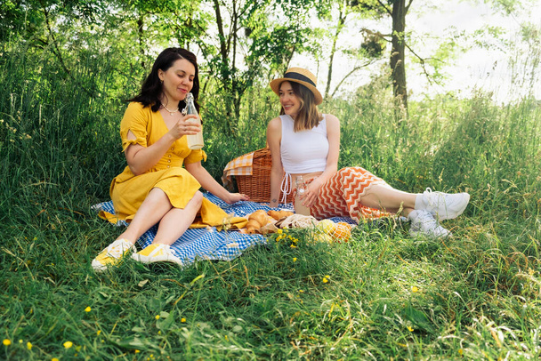 Két barát a kék takarón egy szabadtéri piknikre. - Fotó, kép