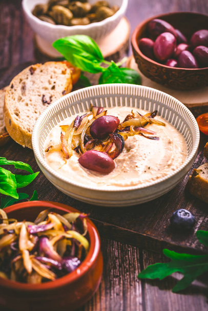 Whipped feta cheese dip with garlic, olives, lemon and caramelized onions. Greek cuisine concept, Tirokafteri dip. - Photo, Image