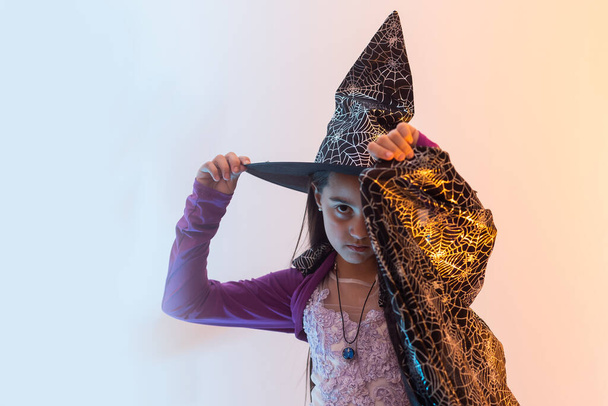 Halloween dziecko w kapeluszu czarownicy wygląda jak uczeń szkoły czarodzieja, szczęśliwy Halloween wakacje - Zdjęcie, obraz