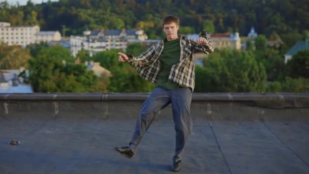 Dynamische Hip-Hop-Performance auf dem Dach durch talentierte kaukasische männliche Tänzer. Engagierter brünetter Mann, der vom Tanz fasziniert ist und beeindruckende Bewegungen und Gesten zeigt. Ausdrucksstarke Körperkonzepte - Filmmaterial, Video