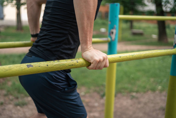 Middle age adult man doing outdoors workout on bars in park, healthy active lifestyle . High quality photo - Photo, Image