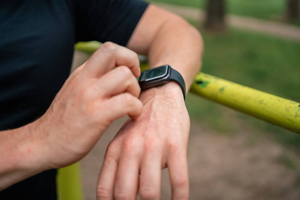 Close-up of man hand with smartwatch during outdoors workout. High quality photo - Foto, immagini