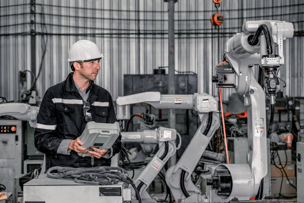 Experienced robotic technicians automate, set up, and give access for a welding process via a control panel display. The production lines are repeatable, reliable, consistent, and self-checking. - Foto, afbeelding