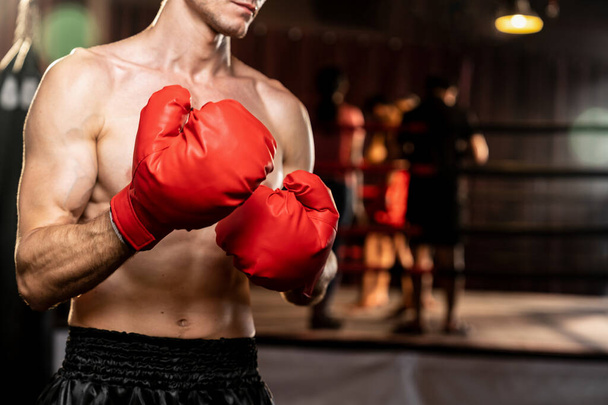 Boxing fighter pozowanie bez koszulki, biały bokser mężczyzna w czerwonej rękawicy w pozycji obronnej straży gotowy do walki i uderzenia na siłowni z pierścieniem i sprzęt bokserski w tle. Impetus - Zdjęcie, obraz