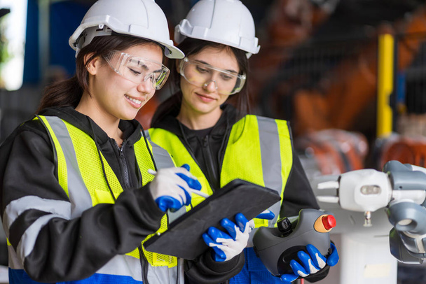 A team of female engineers meeting to inspect computer-controlled steel welding robots. Plan for rehearsals and installation for use. - Photo, Image