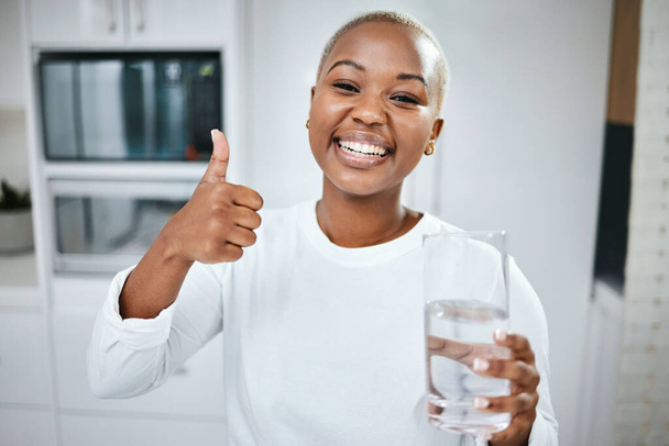 Thumbs up, nutrition and portrait of black woman with water for diet success or detox start. Happy, healthy and an African girl with an emoji hand for liquid goal or care with a glass in the morning. - Fotó, kép