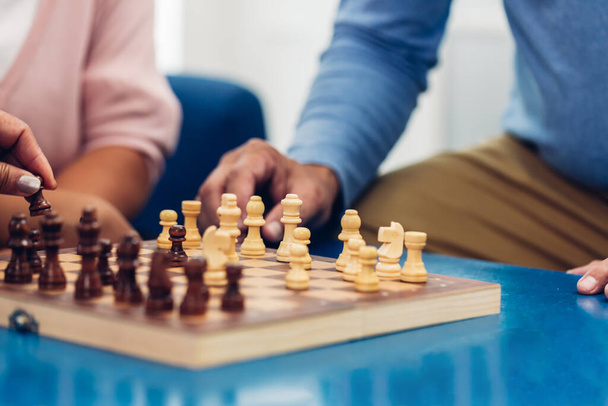 チェスボードゲームをしている人。老人はチェスをしている。成功プレイでチェスを動かす先輩の手。戦略、経営、リーダーシップの概念。ビジネス戦略と戦術の概念は - 写真・画像