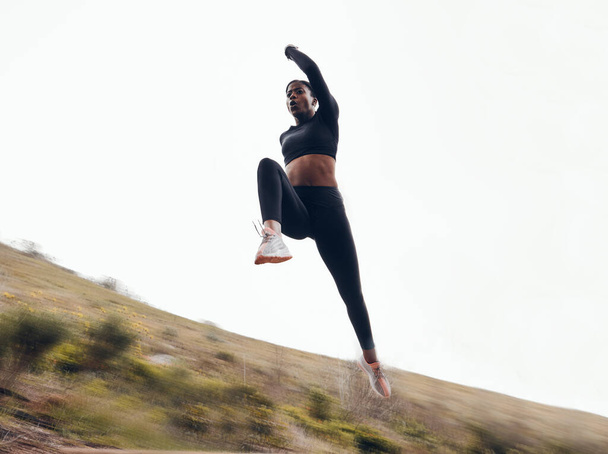 Fitness, running and fast with black woman in nature for health, workout and challenge. Performance, sports and exercise with female runner training in outdoor for speed, marathon and wellness. - Photo, Image