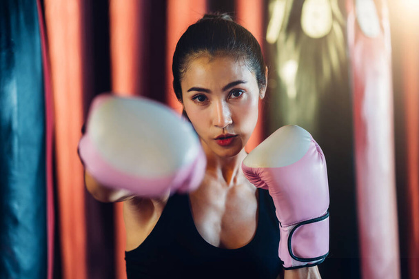 Female Boxer training in Boxing Club. Woman Boxing fighters training at gym. Strong muscular woman practicing box in pink boxing gloves in gym. - Fotografie, Obrázek