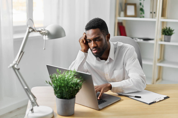 toimisto mies amerikkalainen viestintä desk tietokone kannettava tila kotiin työntekijä verkossa istuu internet afrikkalainen koulutus opiskelija ohjelmoija freelancer työ musta henkilö kopioi chat - Valokuva, kuva