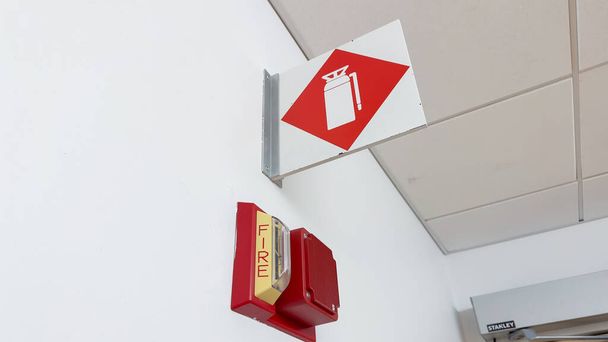 Fire extinguisher and sign, representing safety and preparedness. Symbolic of protection against fire hazards and emergency response - Fotografie, Obrázek