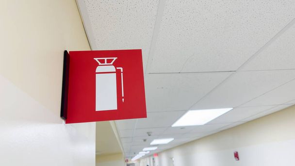 Fire extinguisher and sign, representing safety and preparedness. Symbolic of protection against fire hazards and emergency response - Fotografie, Obrázek