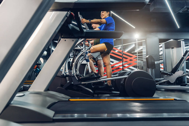 Sports woman with artificial leg running on treadmill at gym. Woman with prosthetic leg using walking on treadmill while working out in gym. - Foto, Imagem