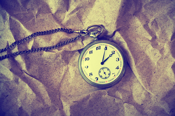 Vintage retro watch on a chain on a vintage paper background - Photo, Image