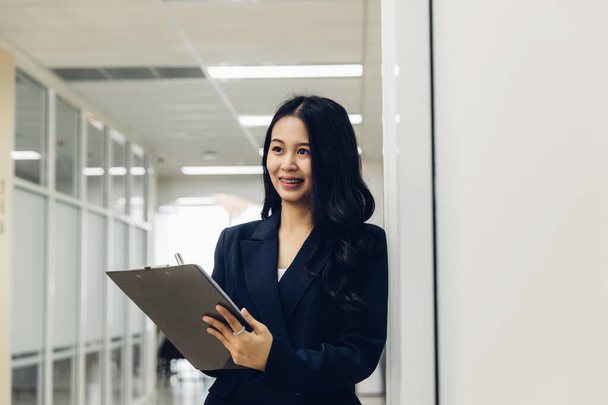 Woman holds a chick list and a pen. Stand up in the modern office. Women leader the new company self-confident. Professional Confident business expert. - Фото, зображення