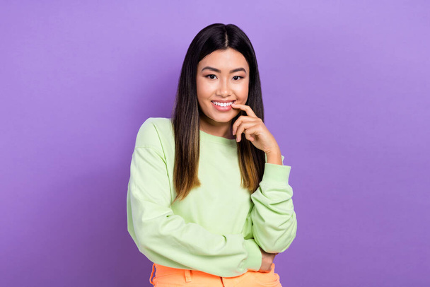 Portrait of pleasant good mood lovely girl wear stylish pullover holding finger on lips smiling isolated on violet color background. - Фото, зображення