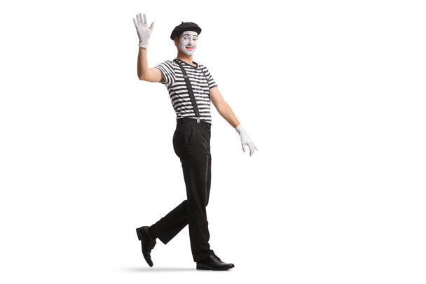 Full length shot of a mime walking and waving isolated on white background - Foto, immagini