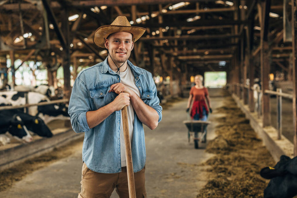 Handsome farmer working in a stable. - Fotoğraf, Görsel
