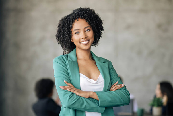 Logro profesional empresarial. Mujer de negocios afroamericana sonriente de pie cruzando las manos con confianza, posando mirando la cámara en la oficina moderna durante la reunión corporativa. Tiro de retrato - Foto, Imagen