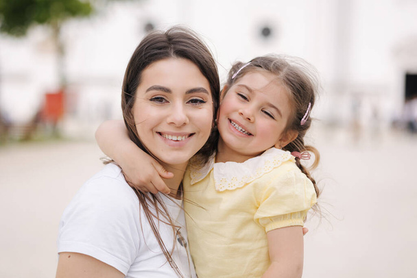 Close-up portrait of adorable daughter with beautiful mom. . High quality photo - Foto, afbeelding