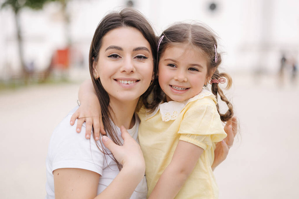 Close-up portrait of adorable daughter with beautiful mom. . High quality photo - Photo, Image