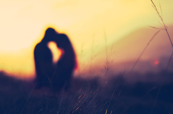 Retro gefiltertes Bild eines romantischen Paares, das Fitness bei Sonnenuntergang umarmt - Foto, Bild
