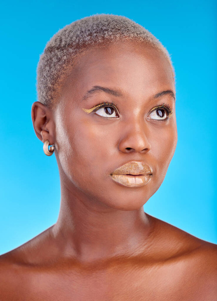 African woman, face and creative makeup, beauty and cosmetics for skincare or natural skin glow on studio blue background. Cosmetic, care and model thinking of idea for facial, treatment or fashion. - Foto, Bild