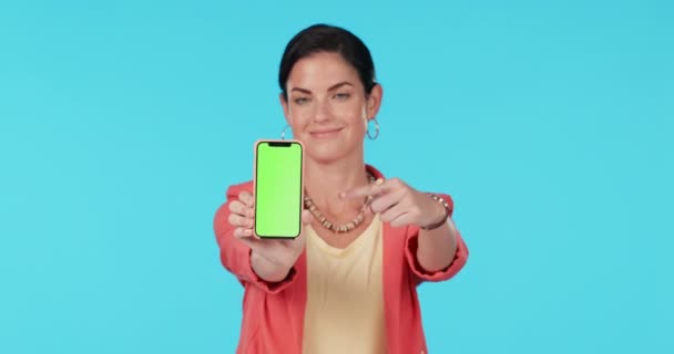 緑の画面電話、スタジオ、モックアップデザイン、ブランドのプレゼンテーションで幸せな女性のポイントと広告スペースを表示します。肖像画、スマートフォンのUIシステムと人のジェスチャーで商業的に青の背景. - 映像、動画