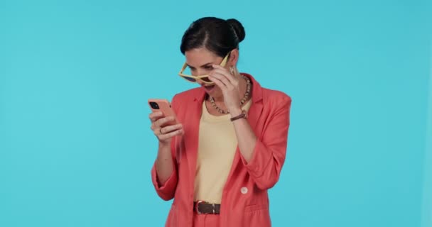 Phone, studio or happy woman on social media surprised by news of sale on internet on blue background. Excited, wow or girl shocked by mobile app notification on discount deal or promotion or offer. - Footage, Video