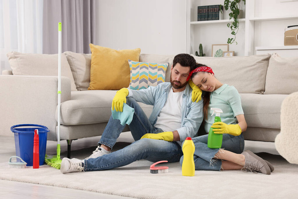 Spring cleaning. Tired couple with detergents and mop in living room - Fotoğraf, Görsel