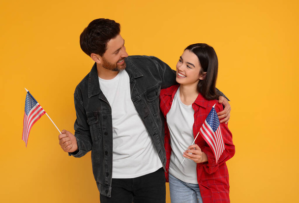 4th of July - Independence Day of USA. Happy man and his daughter with American flags on yellow background - Photo, image