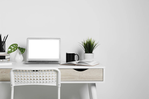 Przytulne miejsce pracy z laptopem, roślinami domowymi i artykułami biurowymi na drewnianym biurku w domu - Zdjęcie, obraz