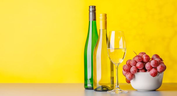 Garrafas de vinho e uvas exuberantes, mostrando a arte da vinificação. Com espaço de cópia - Foto, Imagem