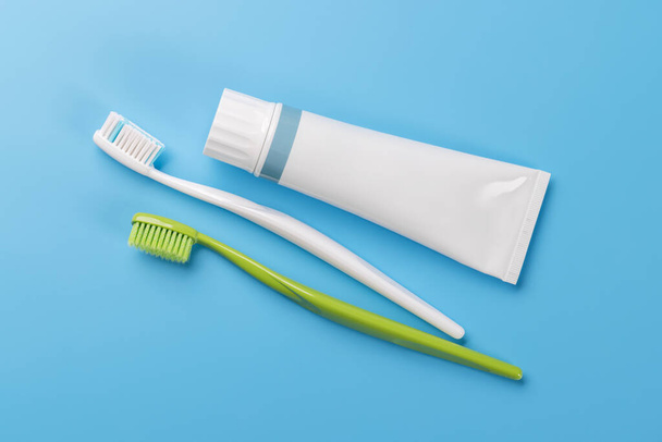 A clean and refreshing image featuring toothpaste and toothbrushes, promoting oral hygiene and a bright smile. Flat lay with copy space - Photo, Image