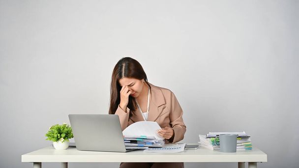 Jonge stressvolle overwerk zakenvrouw gevoel moe werken met papierwerk, witte geïsoleerde achtergrond. - Foto, afbeelding