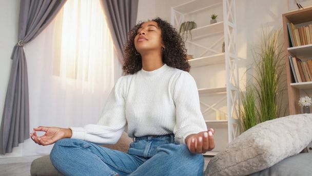 Yoga meditation. Relaxation exercise. Healthy leisure. Calm woman closed eyes sitting floor indoors practicing lotus pose at home. - Valokuva, kuva