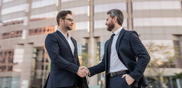 happy two businessmen in suit deal with handshake. photo of two businessmen deal with handshake. two businessmen deal with handshake. two businessmen deal with handshake outdoor. - Φωτογραφία, εικόνα