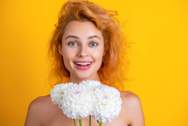 amazed woman beauty with flowers on background. photo of woman beauty with chrysanthemum flowers. woman beauty with flowers isolated on yellow. woman beauty with flowers in studio. - Фото, изображение