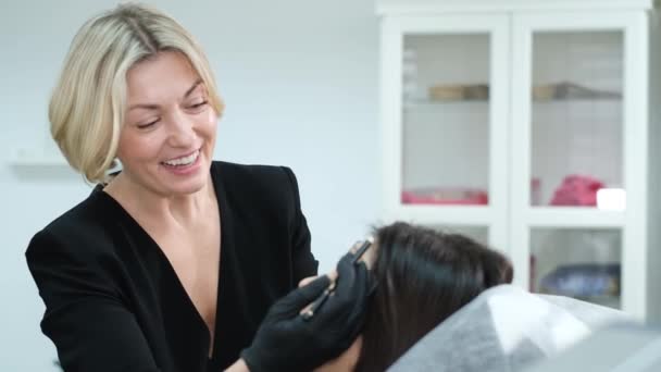 Permanent eyebrow makeup - a treatment in a beauty salon. A cosmetologist performs the eyebrow correction procedure. - Záběry, video