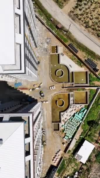 Stap in de toekomst met deze verticale video, het aanbieden van een luchtfoto van een hoogbouw in aanbouw. Aanschouw de fundering wordt gelegd, vloeren stijgen, en de structuur krijgt vorm in een - Video