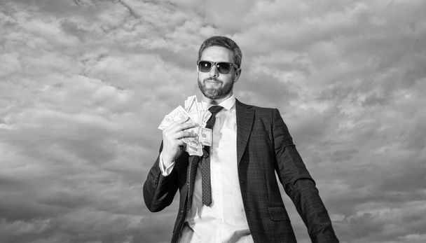 richness of man with money outdoor, earnings. richness of man with money in suit. richness photo of man with money. richness of man with money on sky background. - Photo, Image