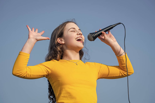 happy teen child singing karaoke in microphone. - Фото, зображення