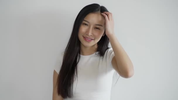 Krásná thajská žena s minimalistickým oblečením s úsměvem a pózování na bílém pozadí. - Záběry, video