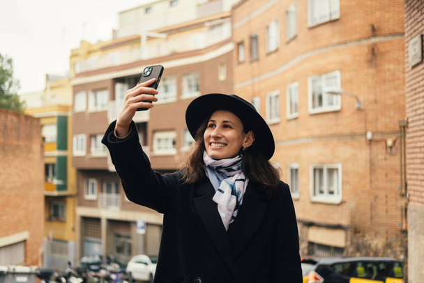 Iloinen nuori turisti nainen ottaa valokuvan vanhassa Euroopan kaupungissa. - Valokuva, kuva