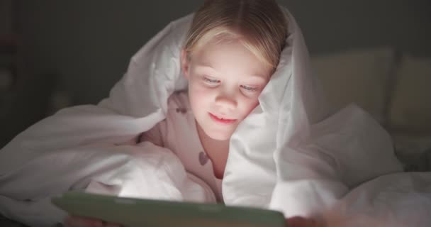 Battaniye, çocuk ve tablet gece yatak odasında online oyunlar, kitap okumak ve eğitim uygulaması için. Genç kız dijital teknoloji, bağlantı ve çizgi film eğlencesi ile rahatla. - Video, Çekim