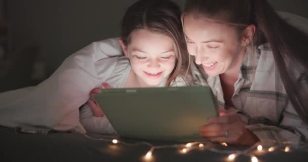 Tablet, night and mother with daughter in bedroom for storytelling, streaming and watching movies. Happy, internet and technology with woman and girl in family home for subscription, online and media. - Footage, Video